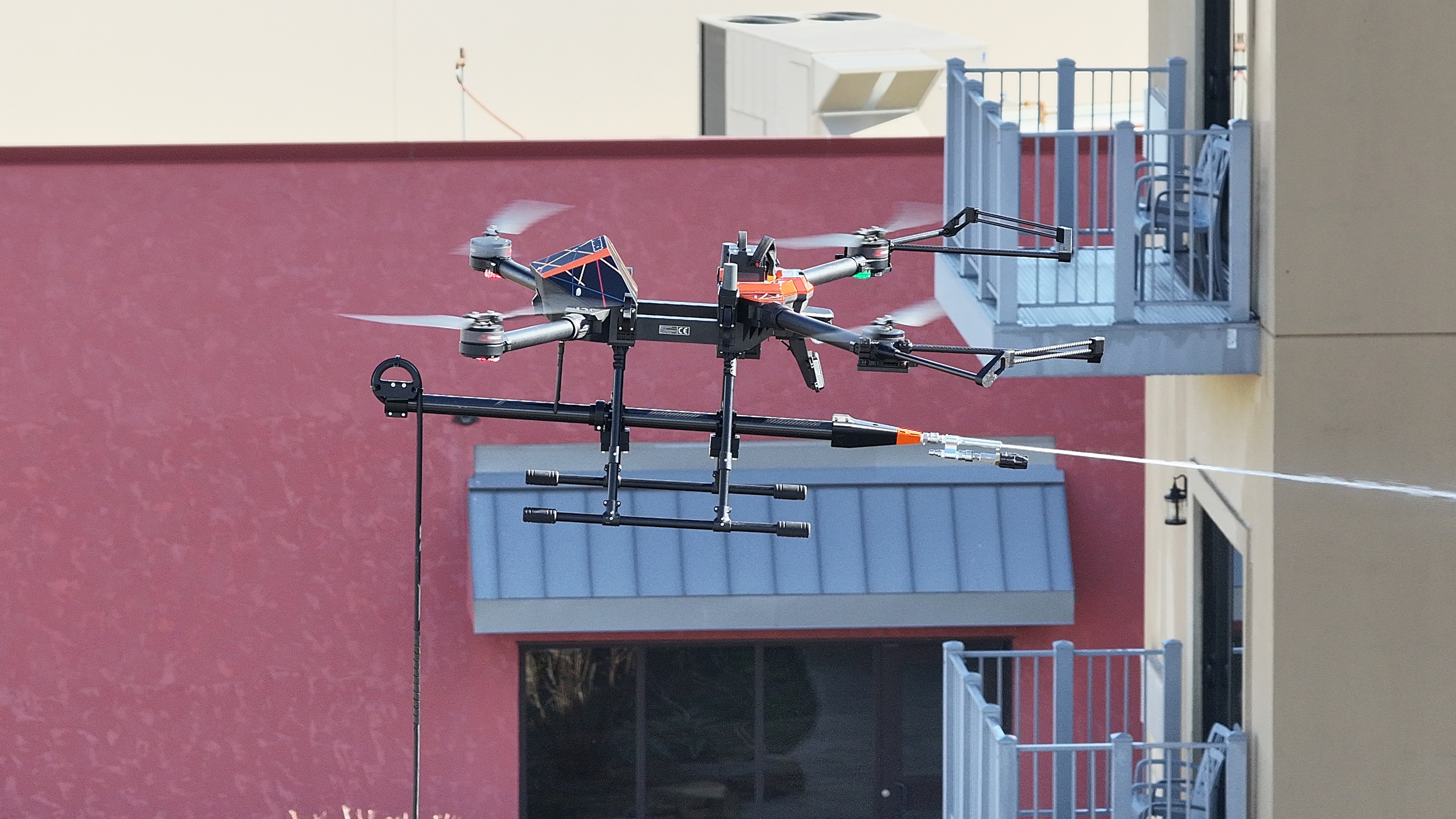 Drone cleaning building exterior at elevation