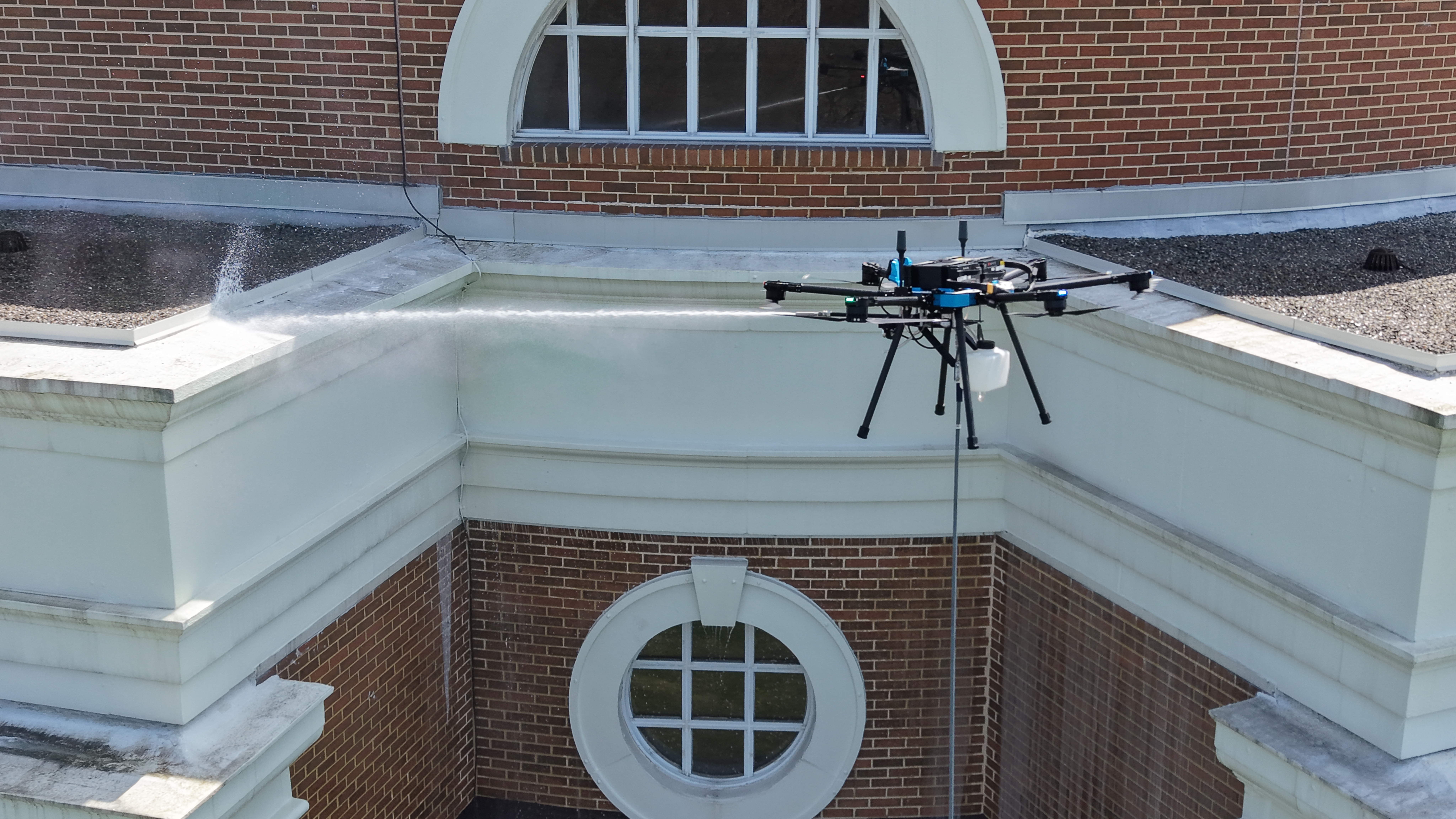 Drone cleaning near building roofline