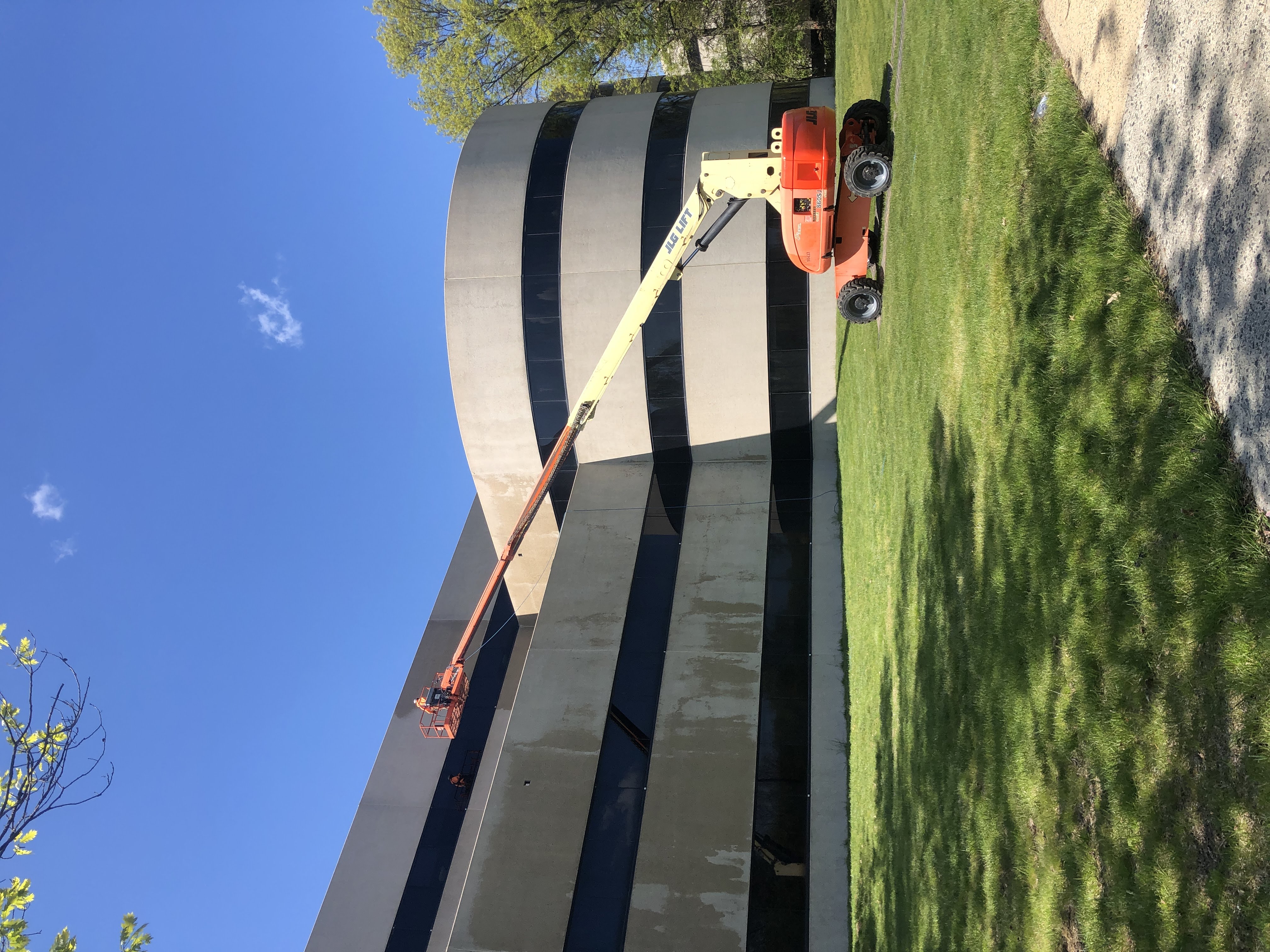 Technician cleaning multi-story building exterior