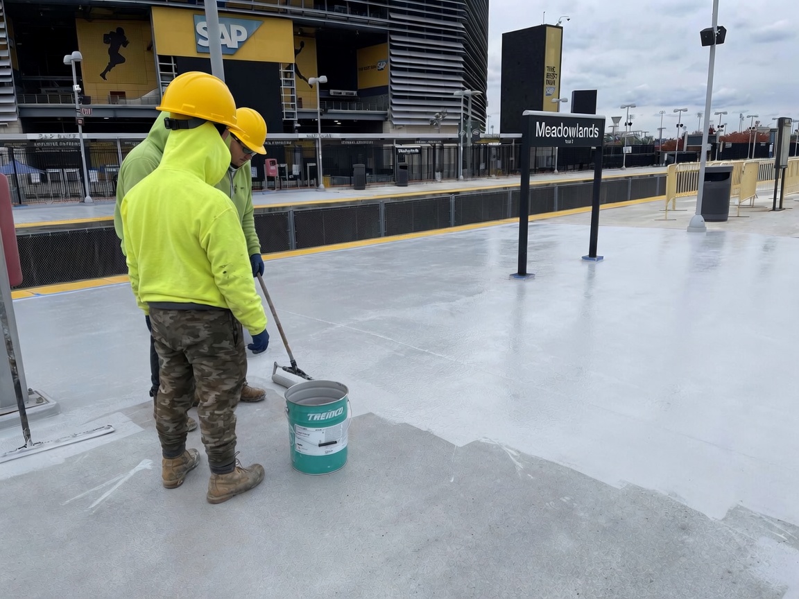 Technician applying plaza deck coating