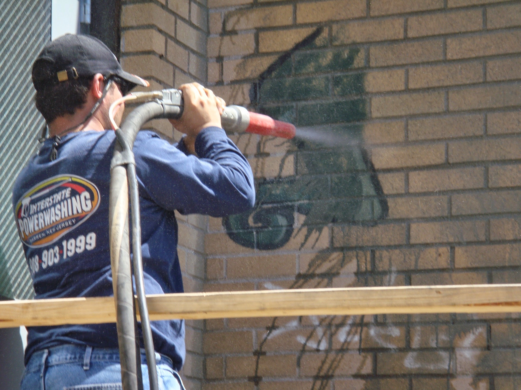 Technician removing coating from masonry surface