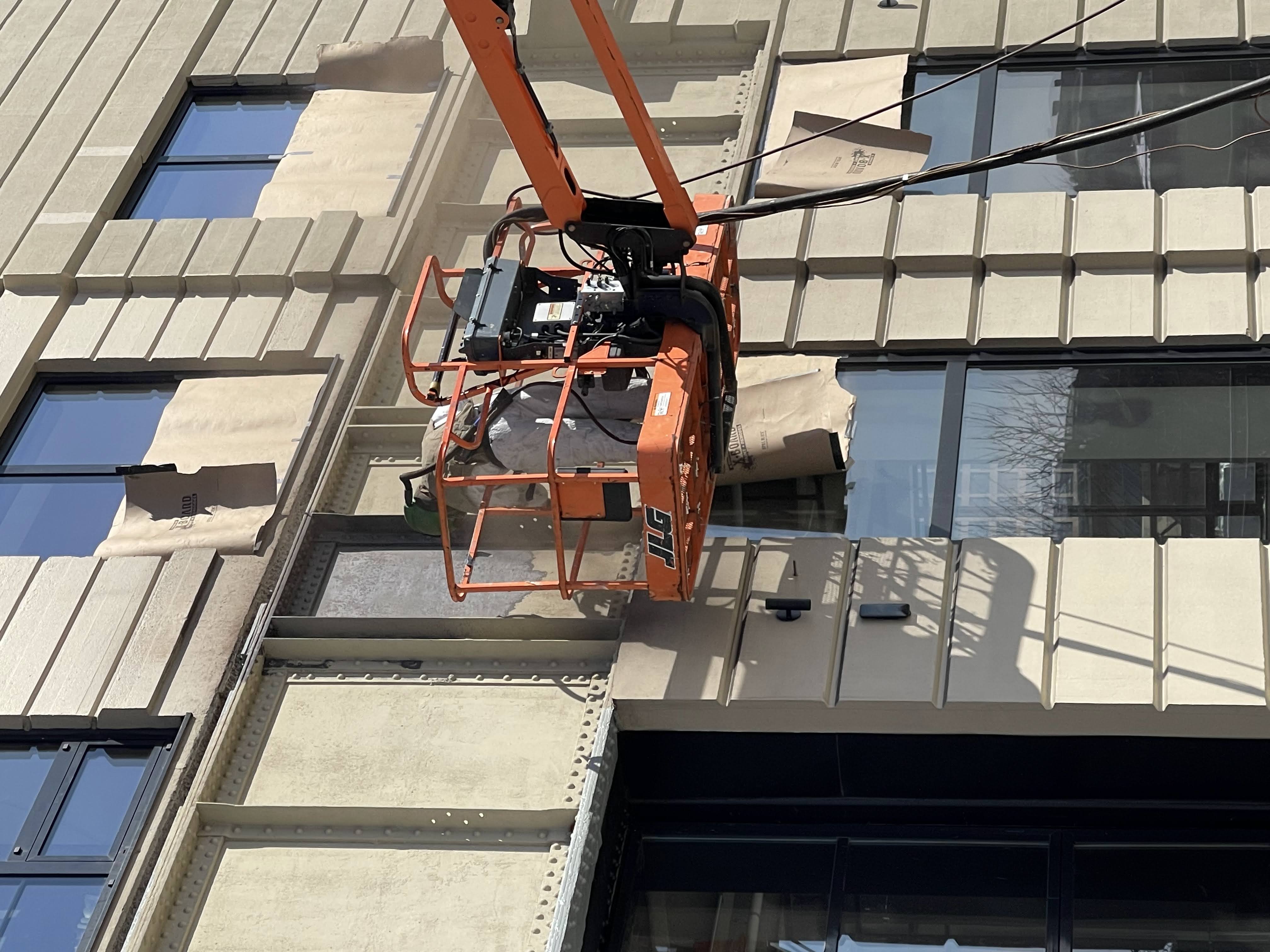 Lift-supported coating removal at building facade
